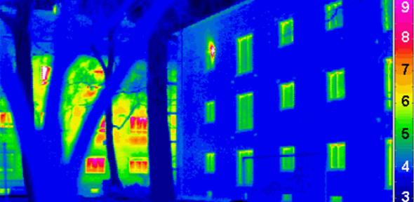 Thermogram of a Passivhaus with a traditional house in the background. Credit: Passivhaus Institut via Wikimedia Commons.